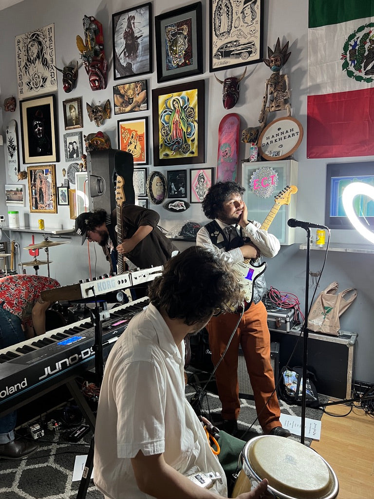 Band playing a live session surrounded by framed art